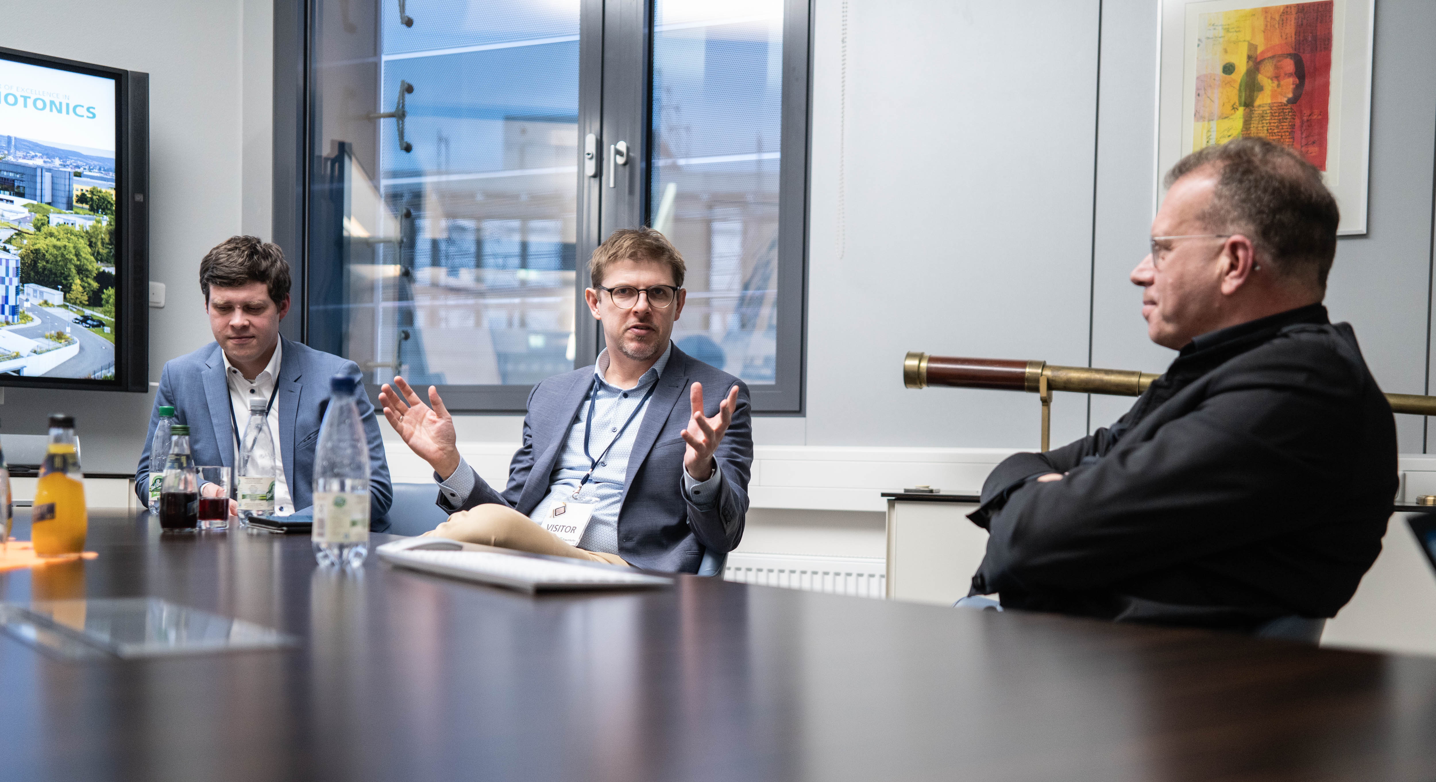  Die Abgeordneten Lutz Liebscher und Matthias Ecke (v. l. n. r.) im  Gespräch mit Andreas Tünnermann. Alle drei Personen sitzen an einem Tisch auf einer Längsseite im Gespräch zugewandt. 