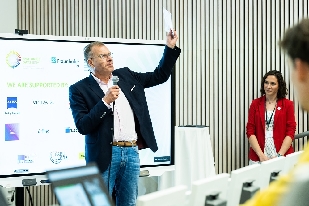 Prof. Dr. Andreas Tünnermann, Leiter des Fraunhofer IOF, winkt den Teilnehmenden der Photonics Days Jena 2023 zum Abschied und lädt herzlich dazu ein, nächstes Jahr wieder dabei zu sein.