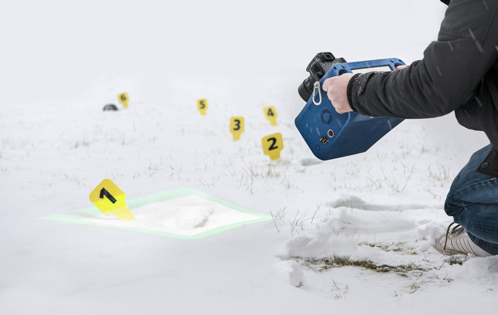 Person nimmt Spuren im Schnee mit dem 3D-Messsystem auf.