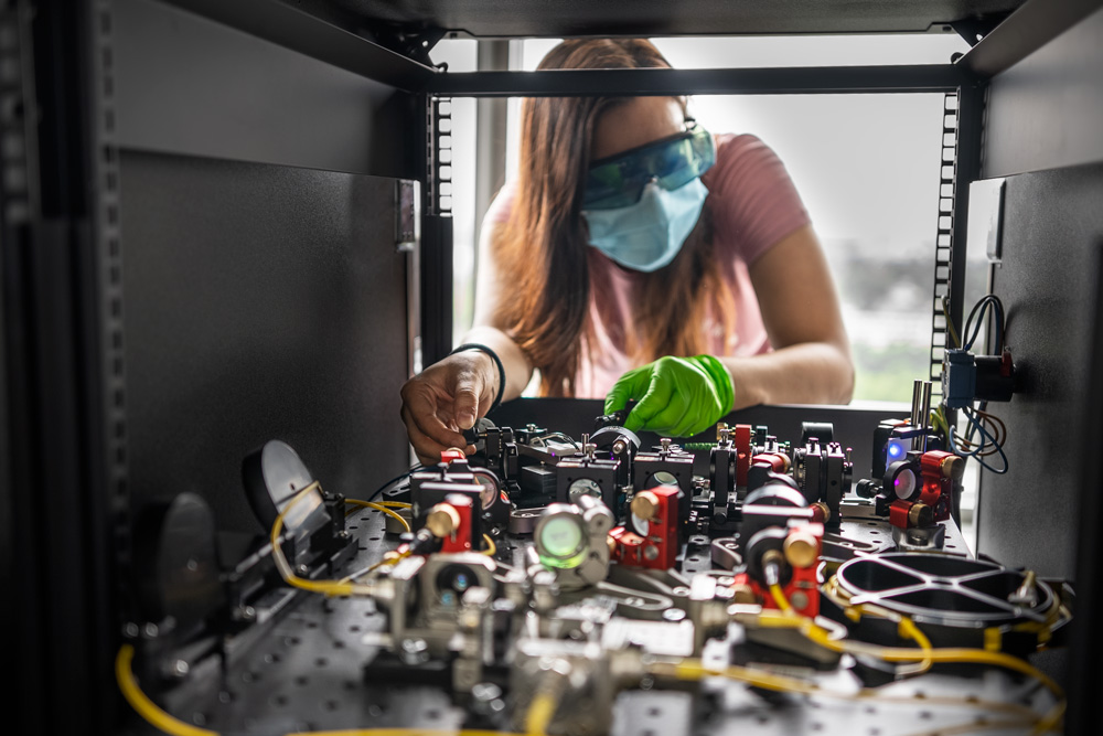 Eine Wissenschaftlerin macht letzte Einstellungen an der Laboraufbau.