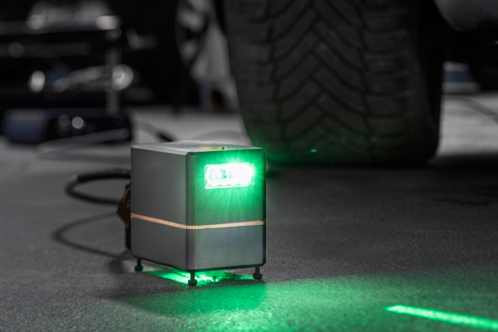 Eine kleine graue Box mit einer grünen hellen LED projeziert eine Fläche von bis zu 100x30 cm. Die Box ist gerade mal 7x7x5 cm klein.