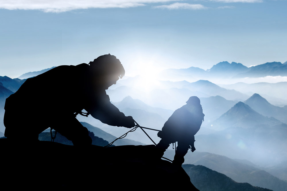 Bergsteiger am Berghang, die sich gegenseitig sichern.