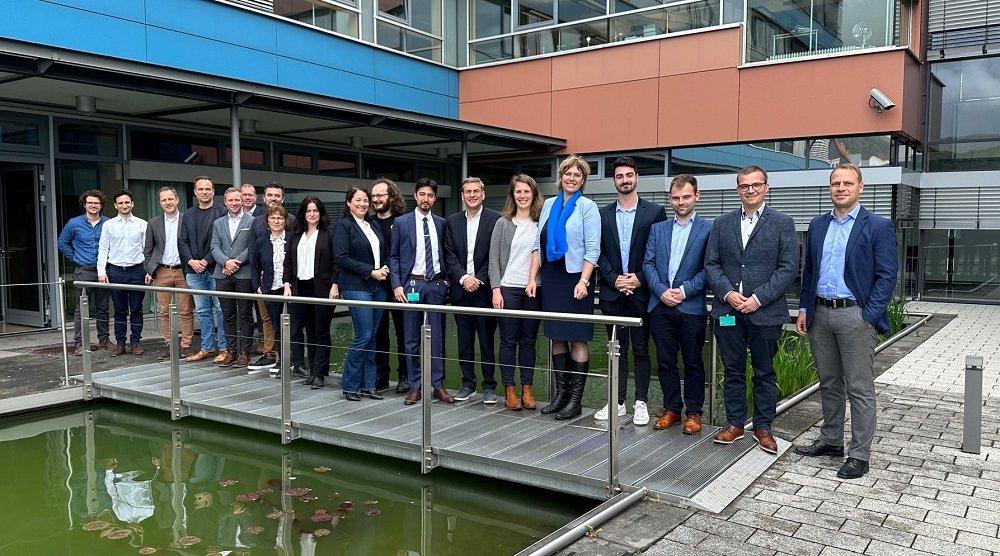 Members of the French delegation and Fraunhofer IOF stand for a group photo in front of the institute building.