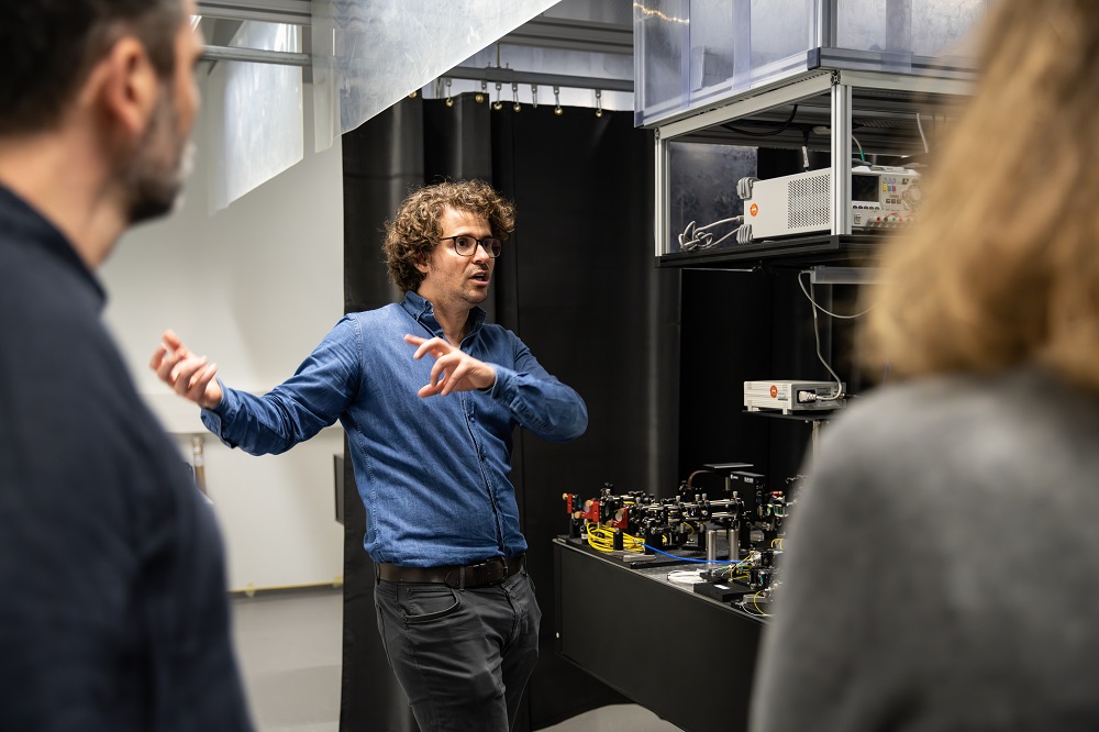 Dr. Fabian Steinlechner together with guests in the laboratory.