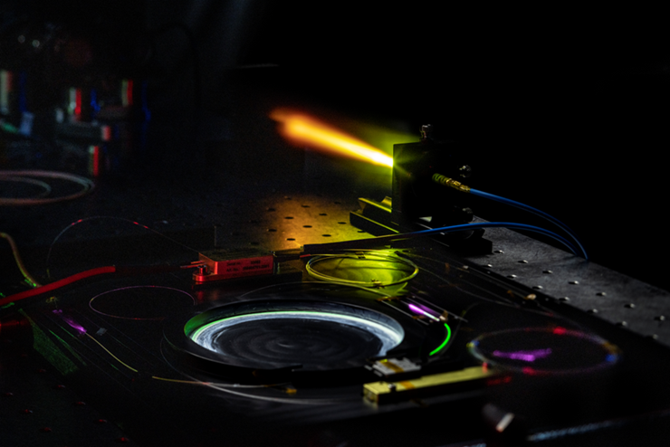 A dark picture of a laser. A short laser beam is coming out of it.