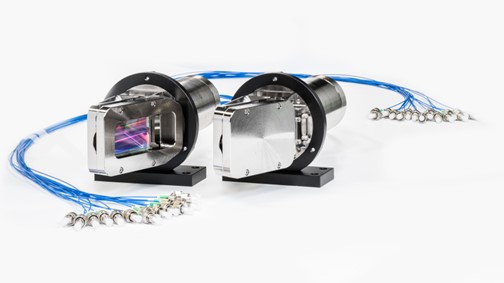 Two devices laying next to each other. They have a round base and a square attatched to the front (comparable to a lightbulb, but with a square). Around them lie blue cords, which are tied together as one.. 