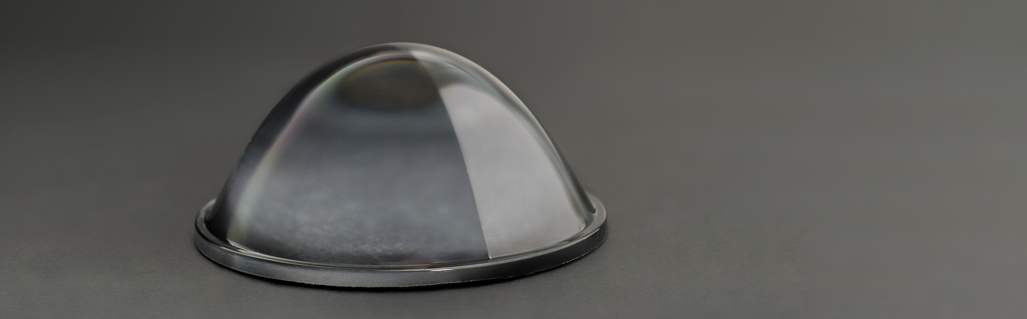 A strongly curved glass lens, half-sided AR-coated.