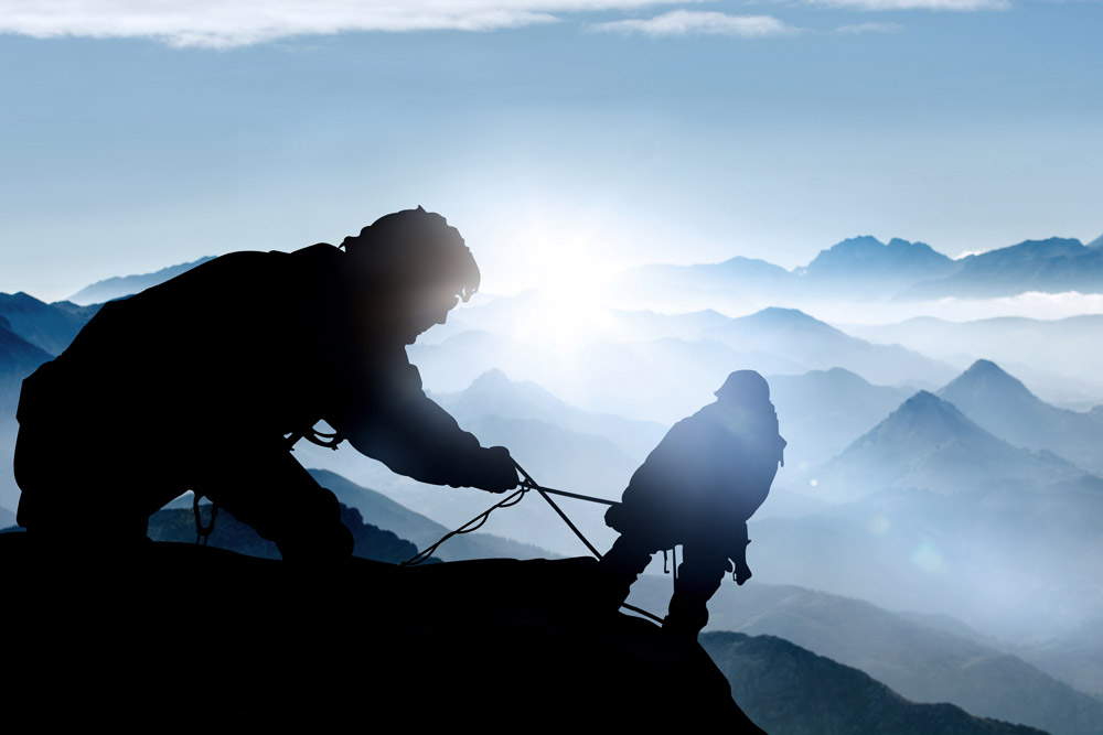 Mountaineers on the mountainside, securing each other.