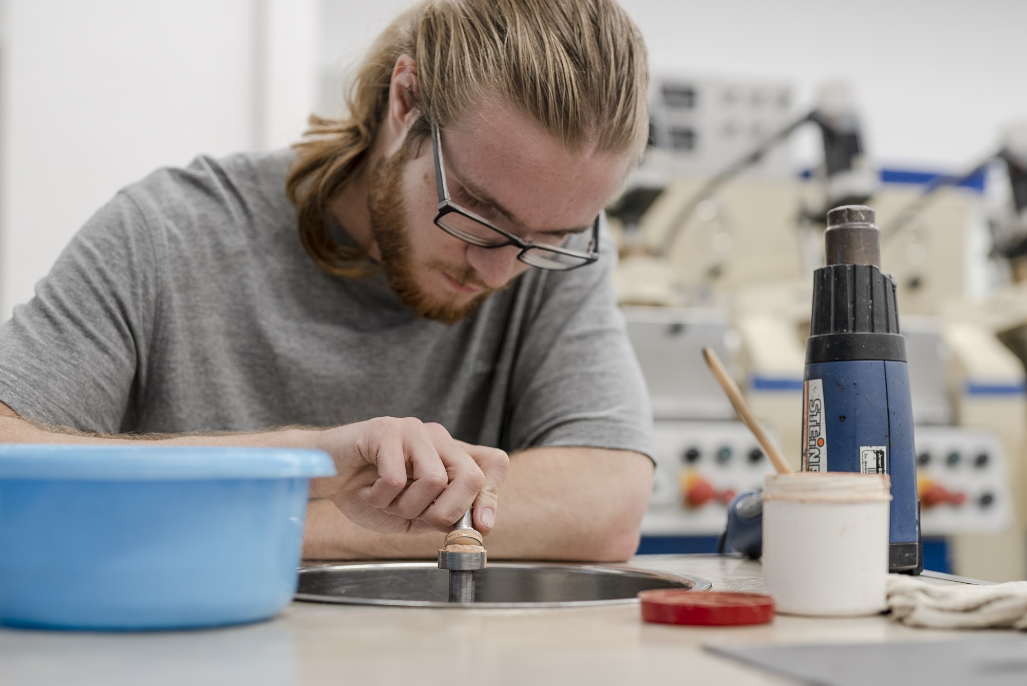 Trainee polishes fine optics at Fraunhofer IOF.