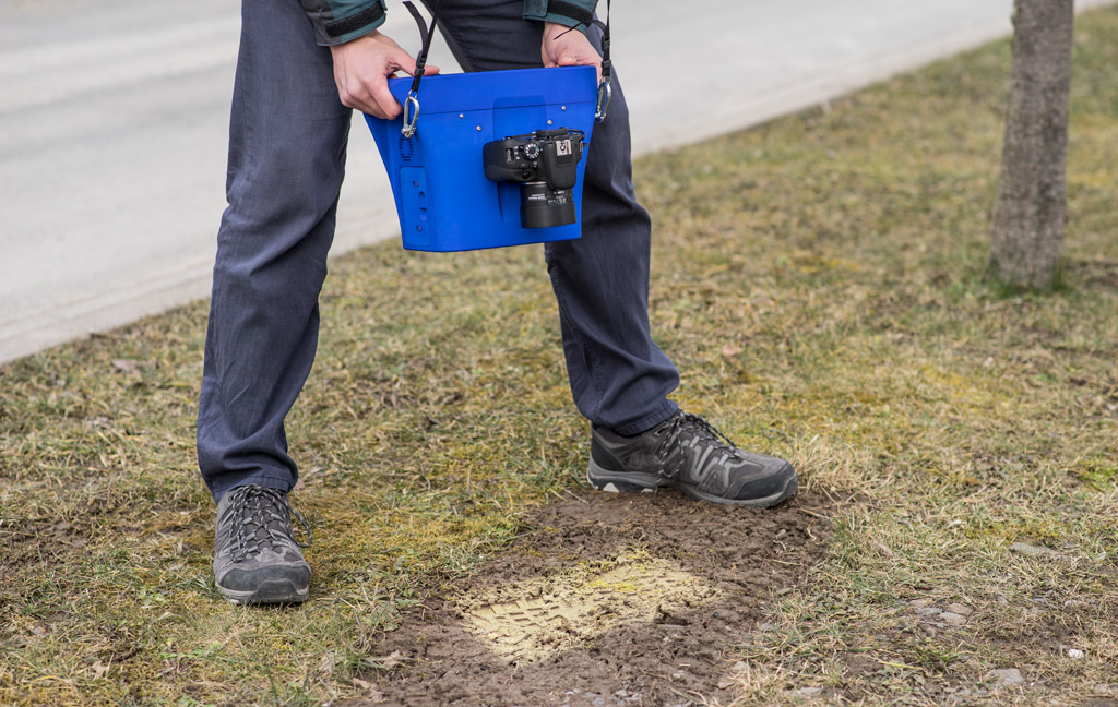 The 3D measuring system above the shoe print in the ground.