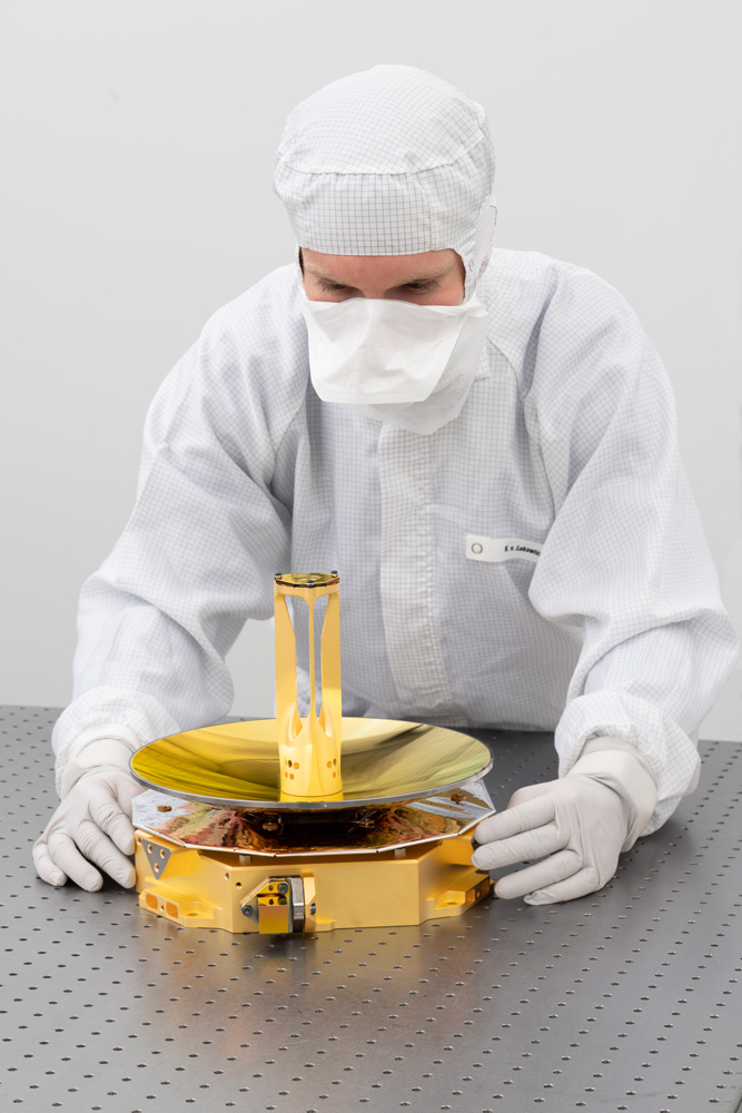 Mirror telescope for instrument GALA between the hands of a researcher.